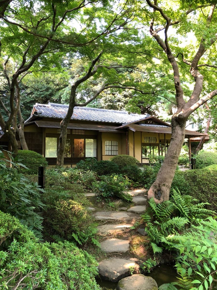 A stone path leading to a traditional Japanese tea house entrance