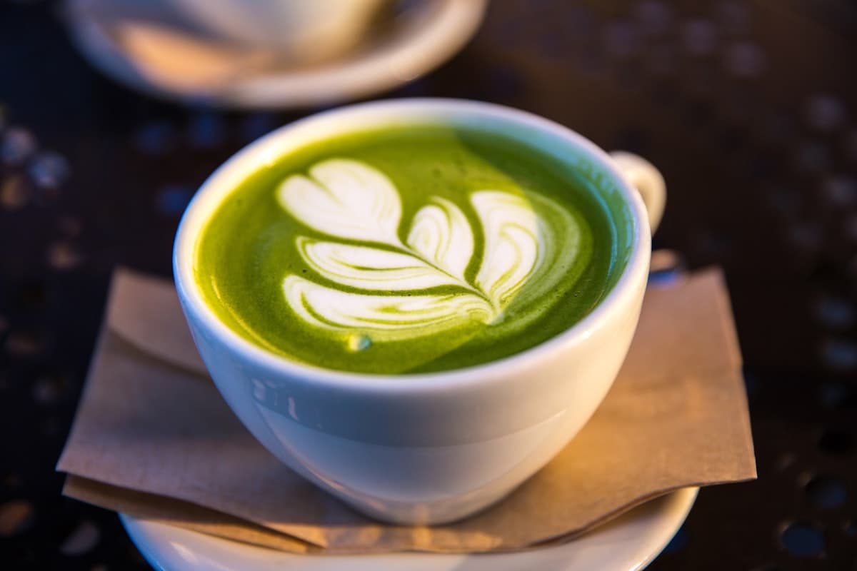 Matcha alert notification on smartphone next to traditional Japanese matcha tea ceremony setup with bowl and whisk